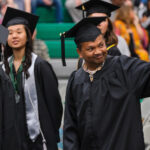 Student graduate waving