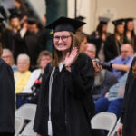 Student waving to the camera