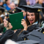 Student smiling and holding a degree