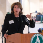 Students and admin speak at a podium in the new success center