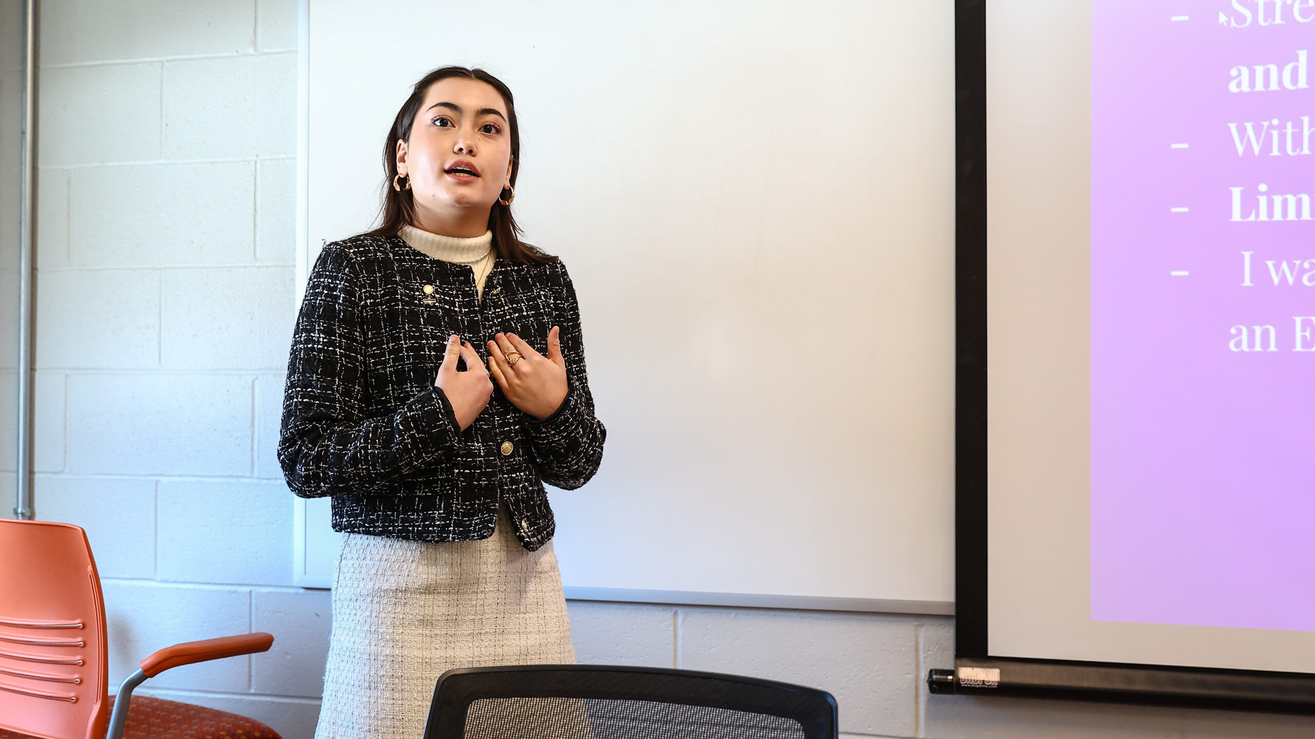 Female high school student presenting in front of a power point