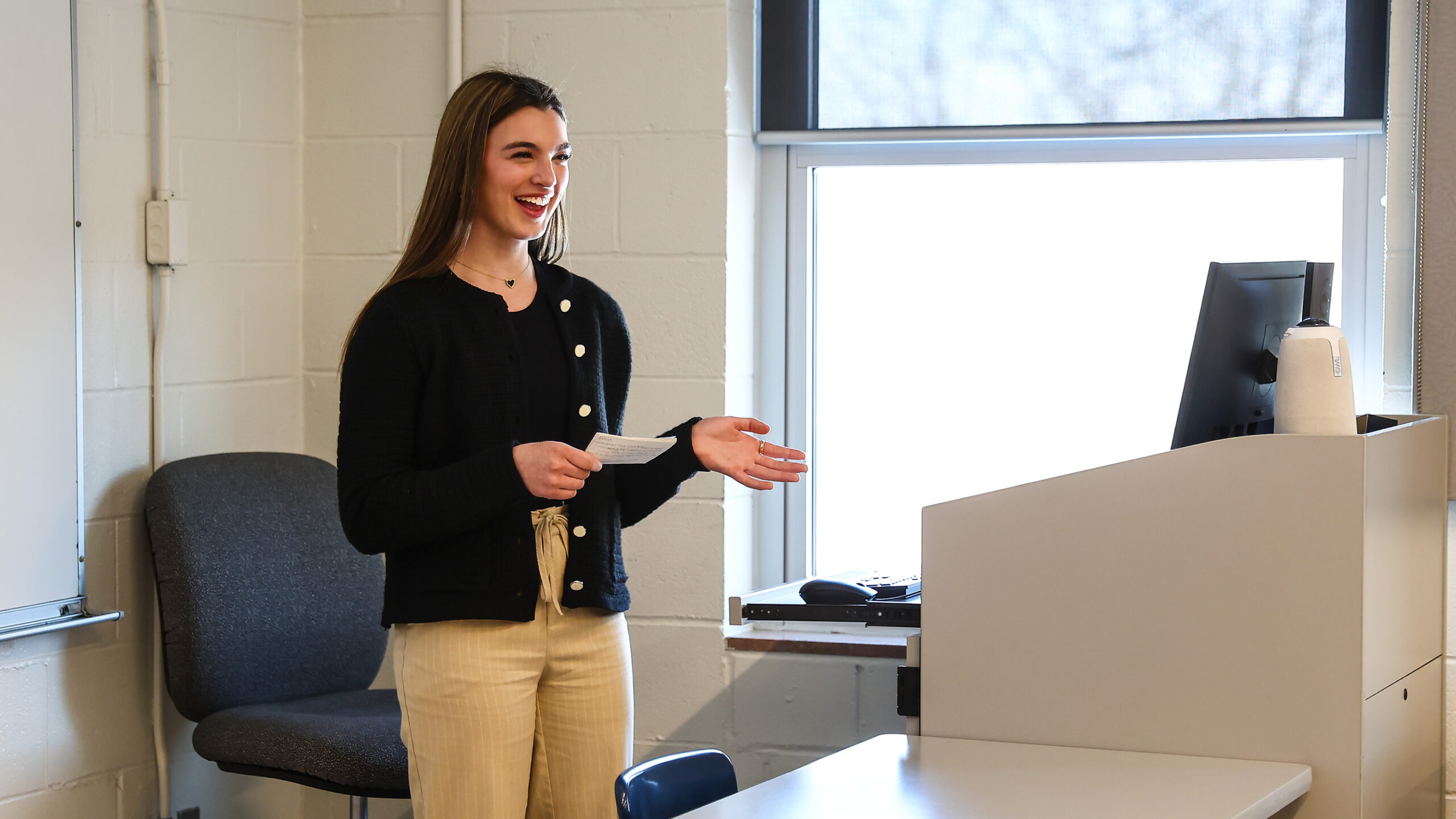 Female high school student standing in front of a podium speaking