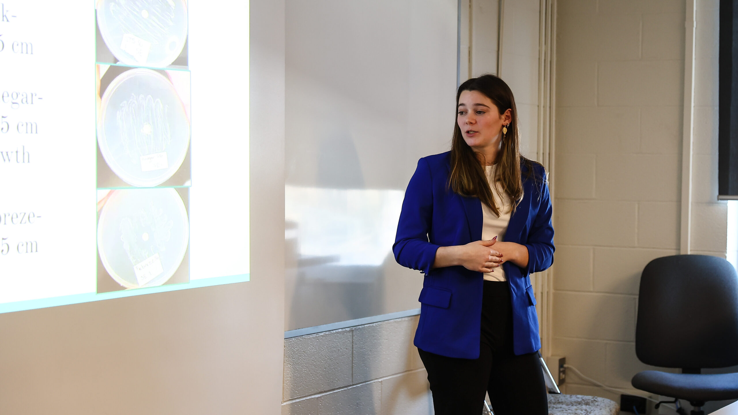 Female high school student presenting in front of a power point