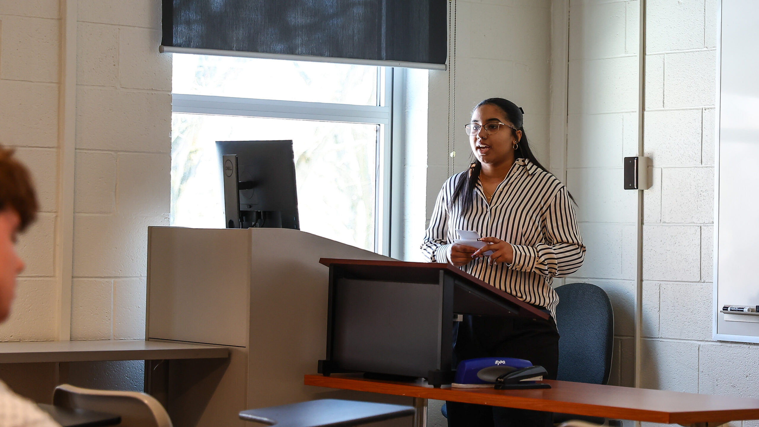Female high school student standing in front of a podium speaking