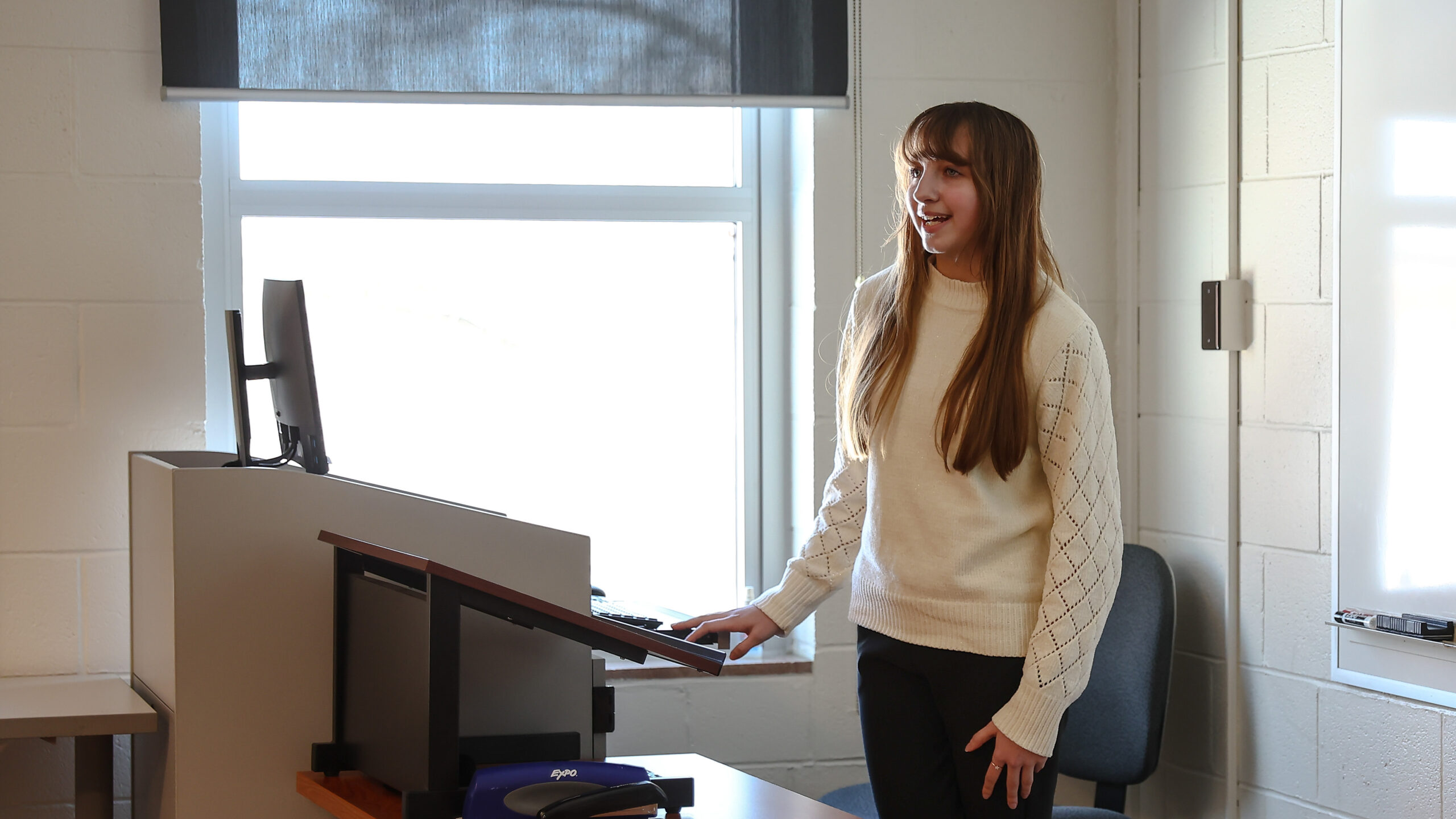 Female high school student standing in front of a podium speaking