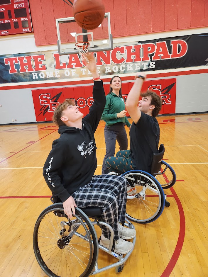 Two high school students playing wheelchair basketball.