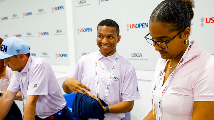 Three interns handing out bags while working at the U.S. Open.