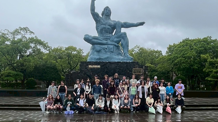 Students standing in front of large statue