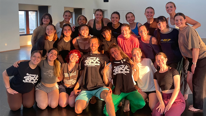 Group of dancers in studio posing for photo.