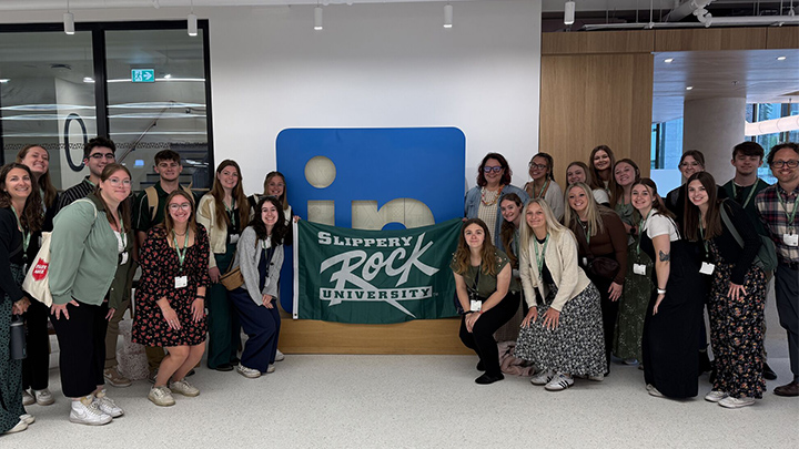Back row, second from left, Thomas Freilino poses in LinkedIn’s Dublin office with SRU students and staff from the Student Engagement and Leadership office, as they met with SRU alumna and LinkedIn employee Nicole Yale, back row, right, holding the SRU flag.