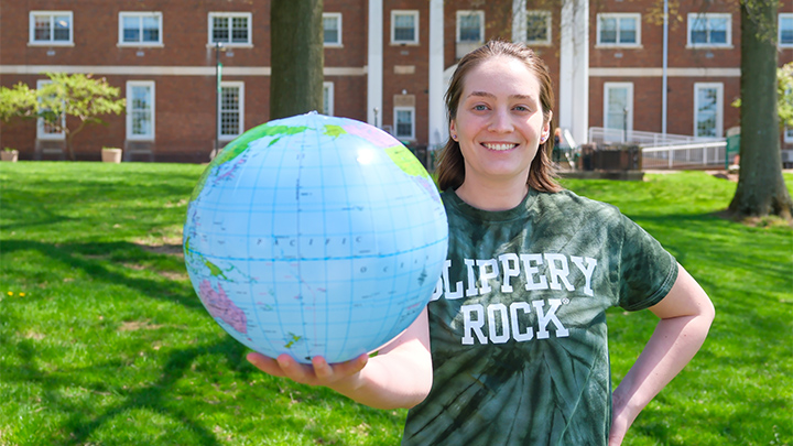 Aria Kriebel, participant in global stufy trip to Japan, poses with globe.