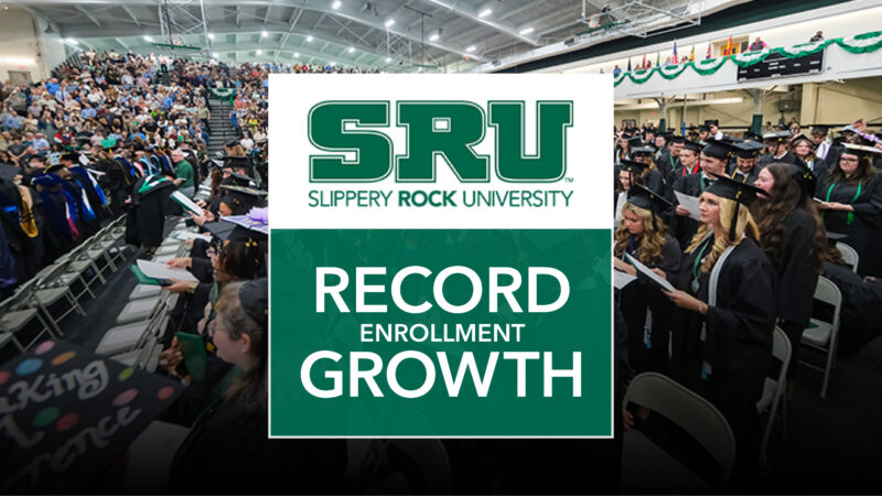Graduates behind a graphic that says SRU Record Enrollment Growth