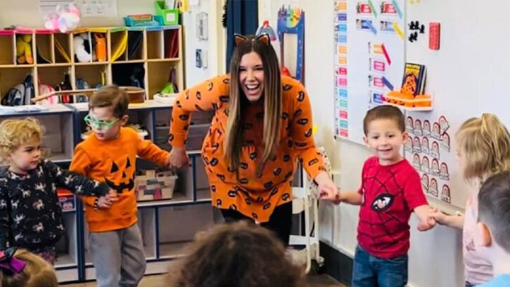 Children in halloween clothes dancing with an instructor.