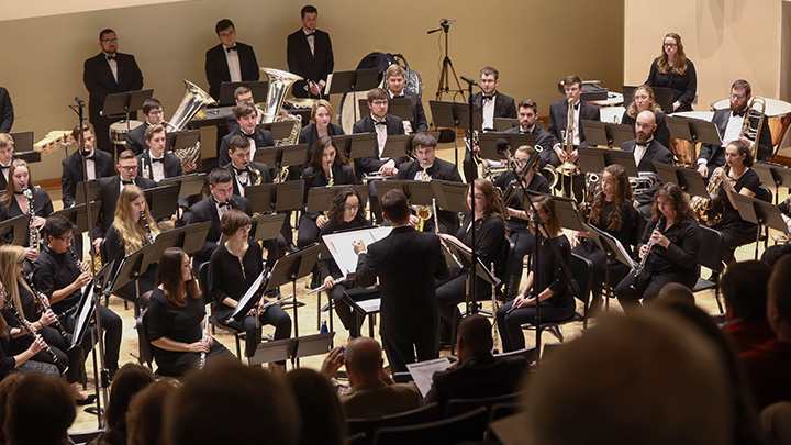 Wind ensemble performing on stage.