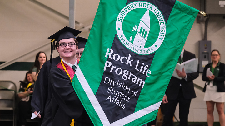 Rock Life student holding a banner during commencement.
