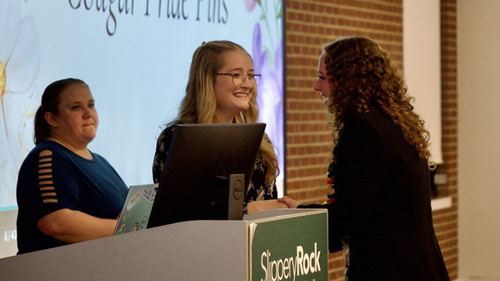 McKenzie talking with students at conference