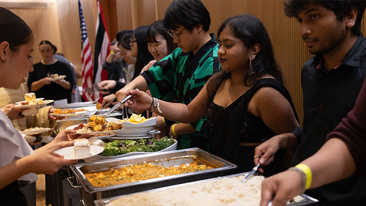 Second from right, Heer Zaveri serves paneer butter masala – a dish from her native North India – to the SRU community at the International Dinner on Nov. 8. A biology major on pre-health professions track, Zaveri is striving to become a cardiothoracic surgeon.