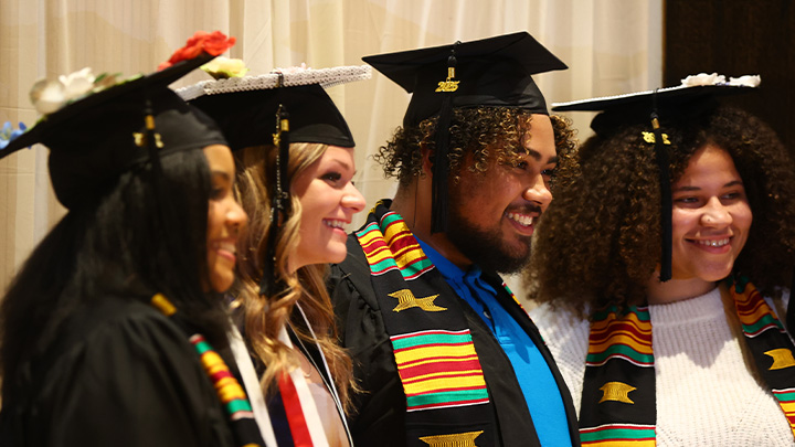 Four graduates with stoles.