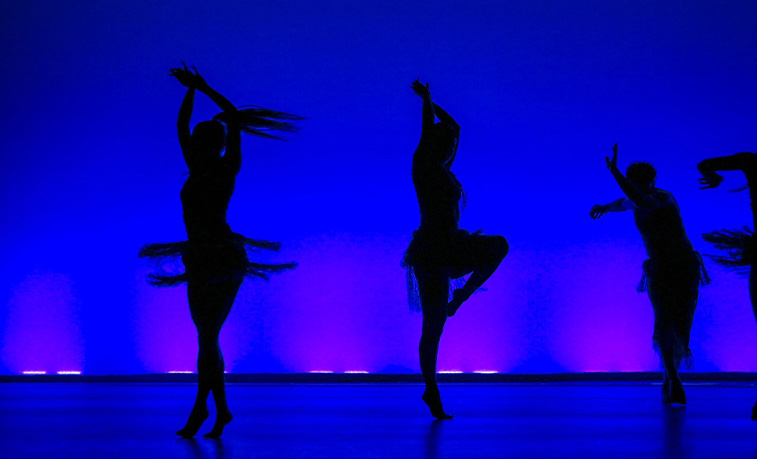 Silhoutted dancers on stage