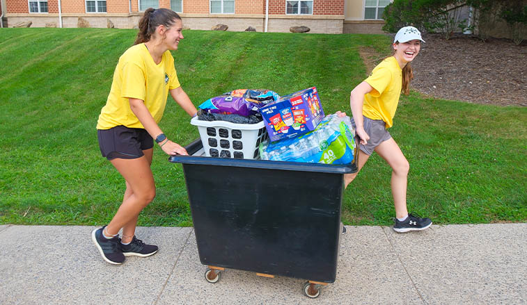 Two students push a cart