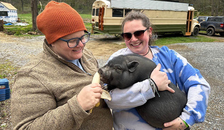 SRU alumni pose with rescued pig