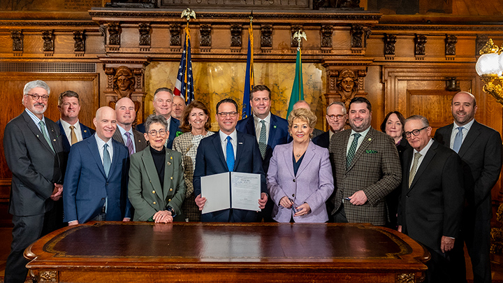 Commission members pose for a signing ceremony at the state capitol building in Harrisburg.