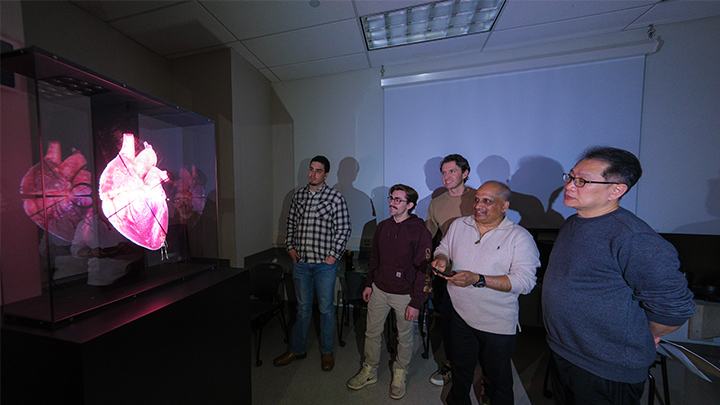 From left, Mason Bush, vice president of operations, HOLOVISN; Isaiah Thompson, an SRU sophomore cybersecurity major; Nick Brucker, co-founder of HOLOVISN; Sam Thangiah, SRU professor of computing and security; and Abdullah Wahbeh, SRU associate professor of computer science; test the new HOLOVISN SmartV that is displaying a 3D image of a human heart.