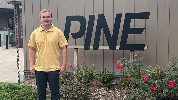 Jason Serbin standing in front of a sign that says PINE