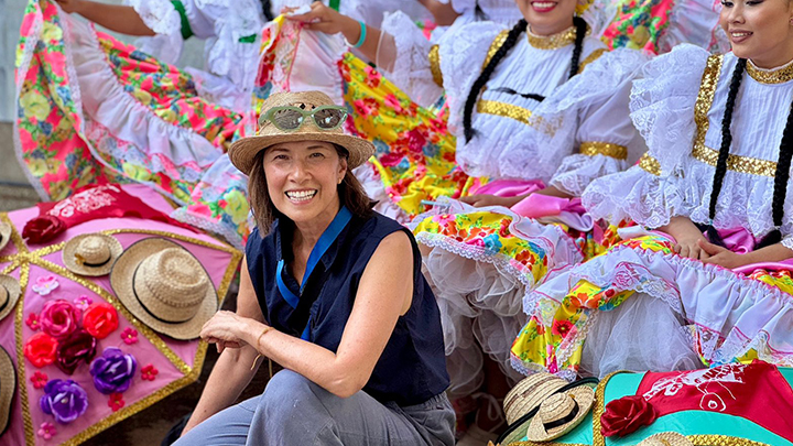 Melissa Teodoro kneeling in front of three Colombian dancers.
