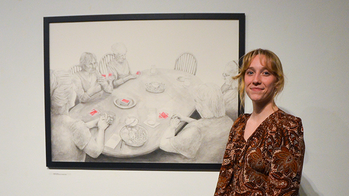 Student standing in front of drawing.