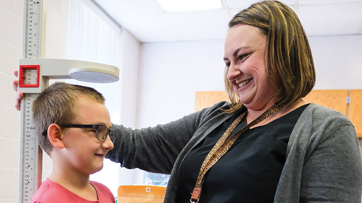 Nurse measuring a child's height in a nurse's office.