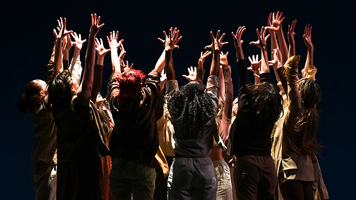 Groups of dancers with arms raised in the air.