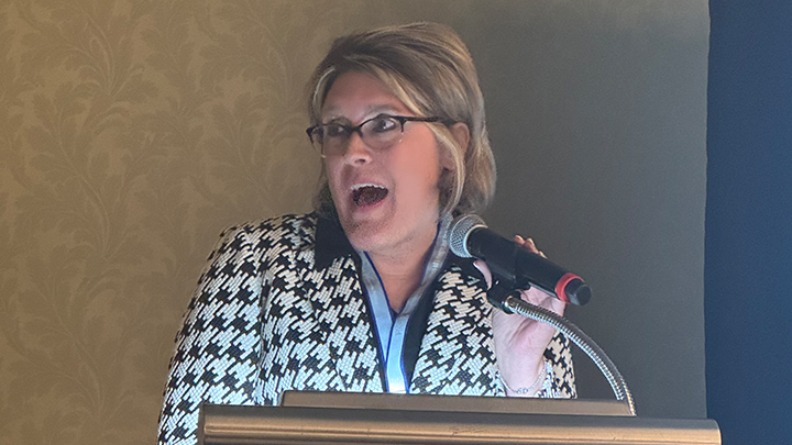 Amy Orville speaking at a podium.