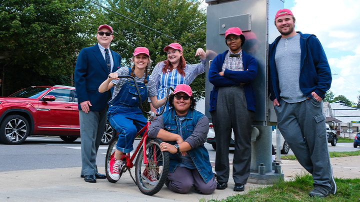 Cast members with red bike.