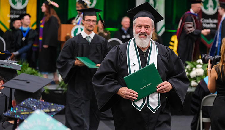 Joe Coudriet walks with his degree