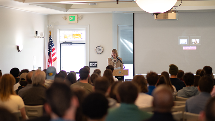 Cindy Adams Dunn addresses a crowd of students at SRU’s Russell Wright Alumni House