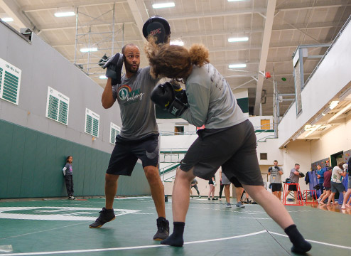 Dallas Jackson and a student practice spar with thick gloves