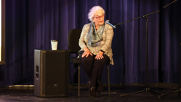 Holocaust survivor Erika Taubner Gold sitting on stage.