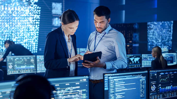Two people looking at a tablet in a computer lab.