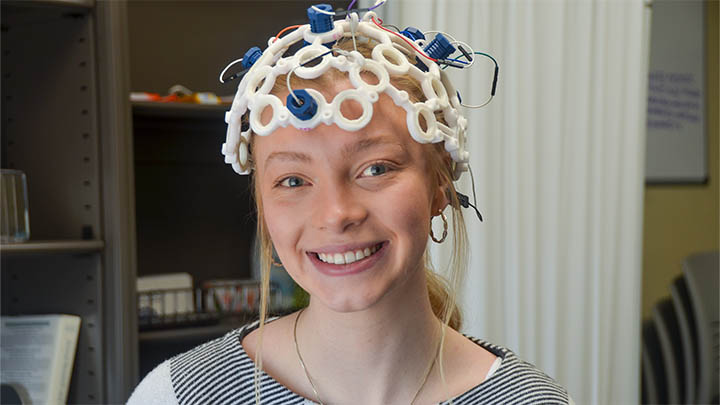 Carmella Ryan wears an electroencephalogram monitor that is used in a cognitive neuroscience research study at Slippery Rock University. Ryan and Shannon McKnight, instructor of psychology, built and programmed the monitor.