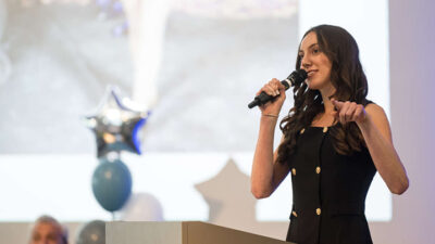 Woman with microphone pointing and presenting