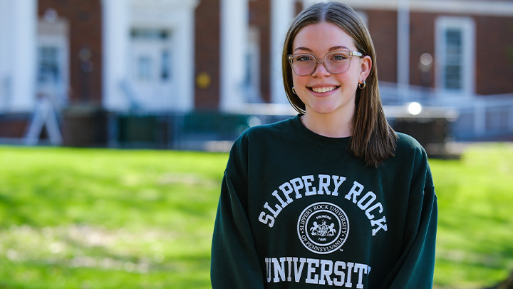 Woman in SRU sweatshirt standing in campus quad.