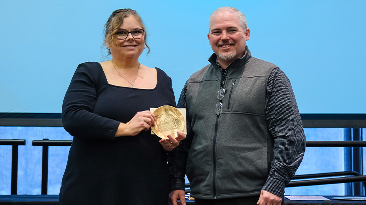 From left, Stacy Bluedorn, administrative assistant of student affairs, is presented the Excellence in Mentoring Award, by Ken Messina, a member of the Pillar One Awards Committee.
