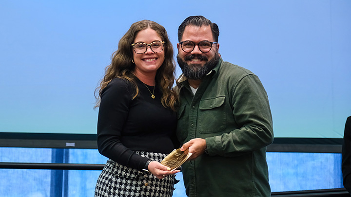 From left, Dallas Kline, assistant director of first-year admissions, is presented the First Choice Award by Aaron George, a member of the Pillar One Awards Committee.