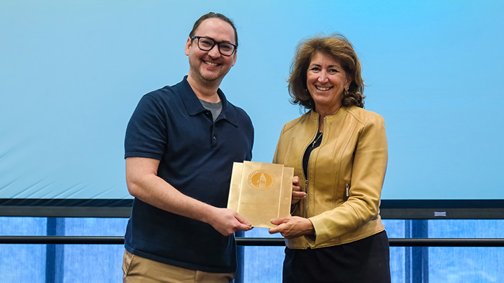 From left, Timothy Little Tran, associate professor of music, is presented the 2026 Above and Beyond Award by SRU President Karen Riley.