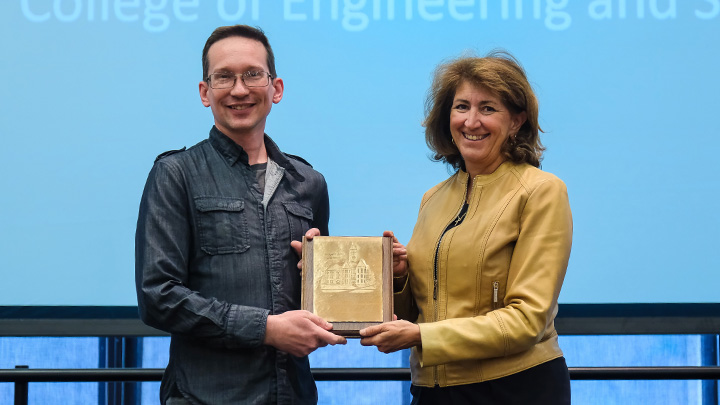 From left, Christopher Maltman, associate professor of biology, is presented the 2026 President’s Award for Scholarly and Creative Achievement by SRU President Karen Riley.