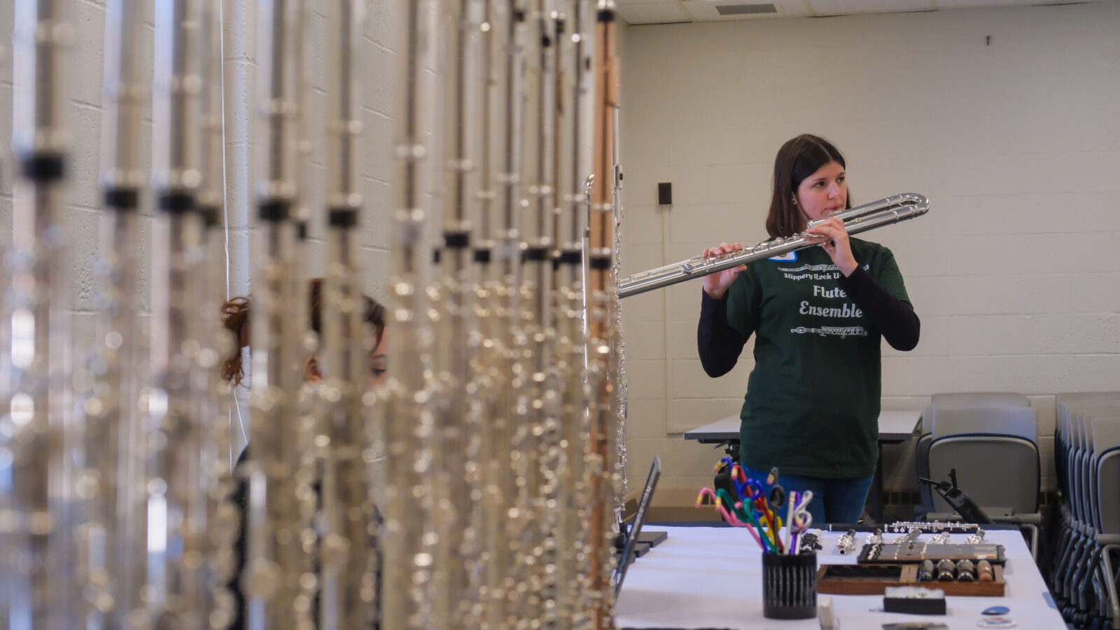 Cadence Durnell, a student, tests a bass flute