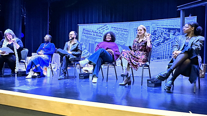 Six panelists sitting on a stage with newspaper headlines as the background.