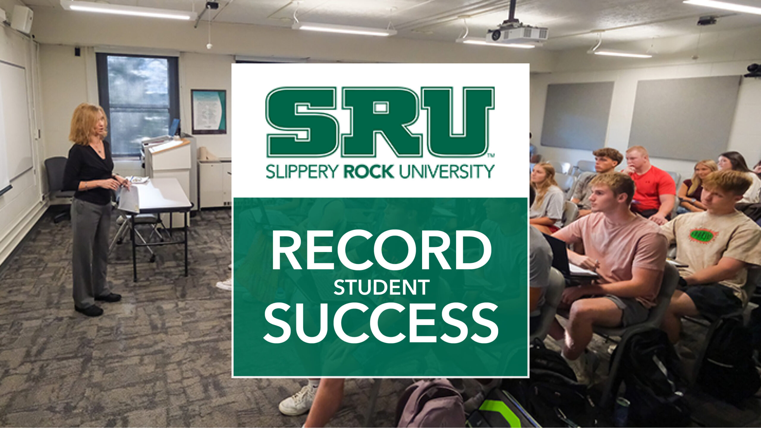 Classroom with professor teaching students behind a graphic that says SRU Record Student Success.