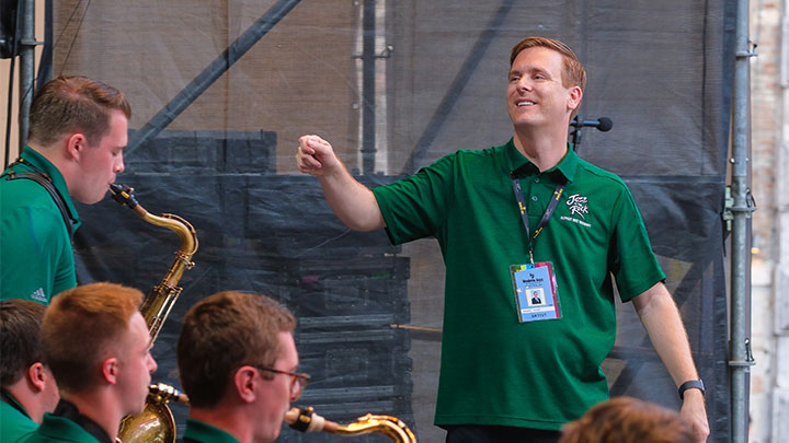 Jason Kush conducting a jazz band with saxophone players.